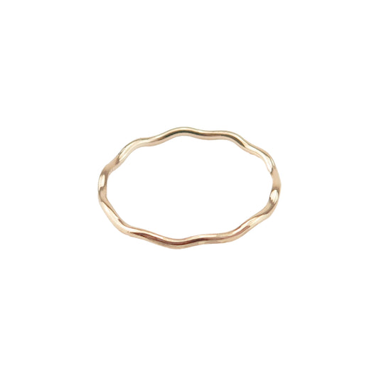 A gold stacking ring with a wave design on a white background.
