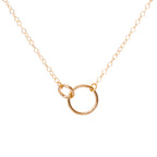 Gold necklace with a circular pendant on a white background