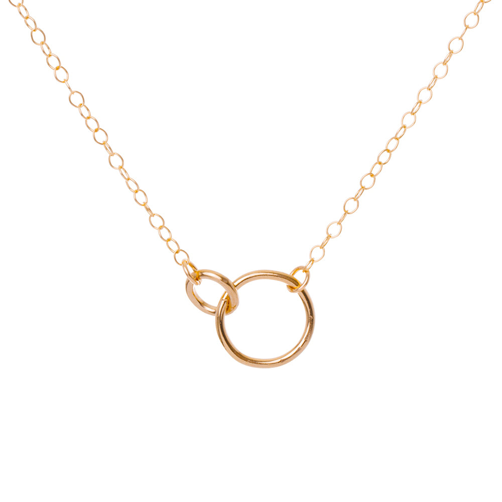 Gold necklace with a circular pendant on a white background