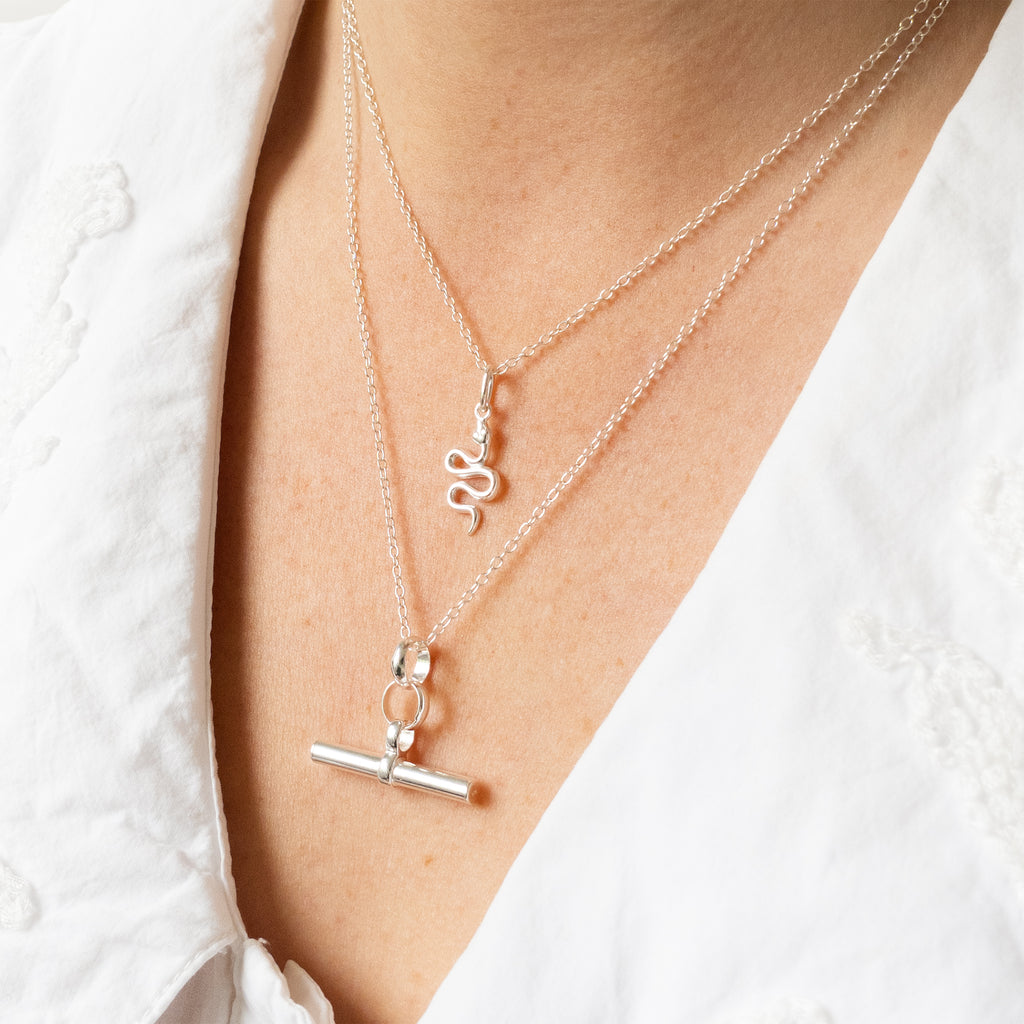 Silver necklaces with unique pendants on a white background