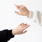 Two hands with rings on a white background