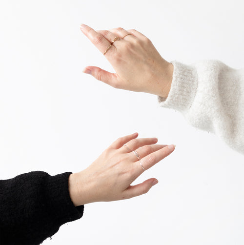 Two hands with rings on a white background
