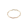 A gold stacking ring with a wave design on a white background.