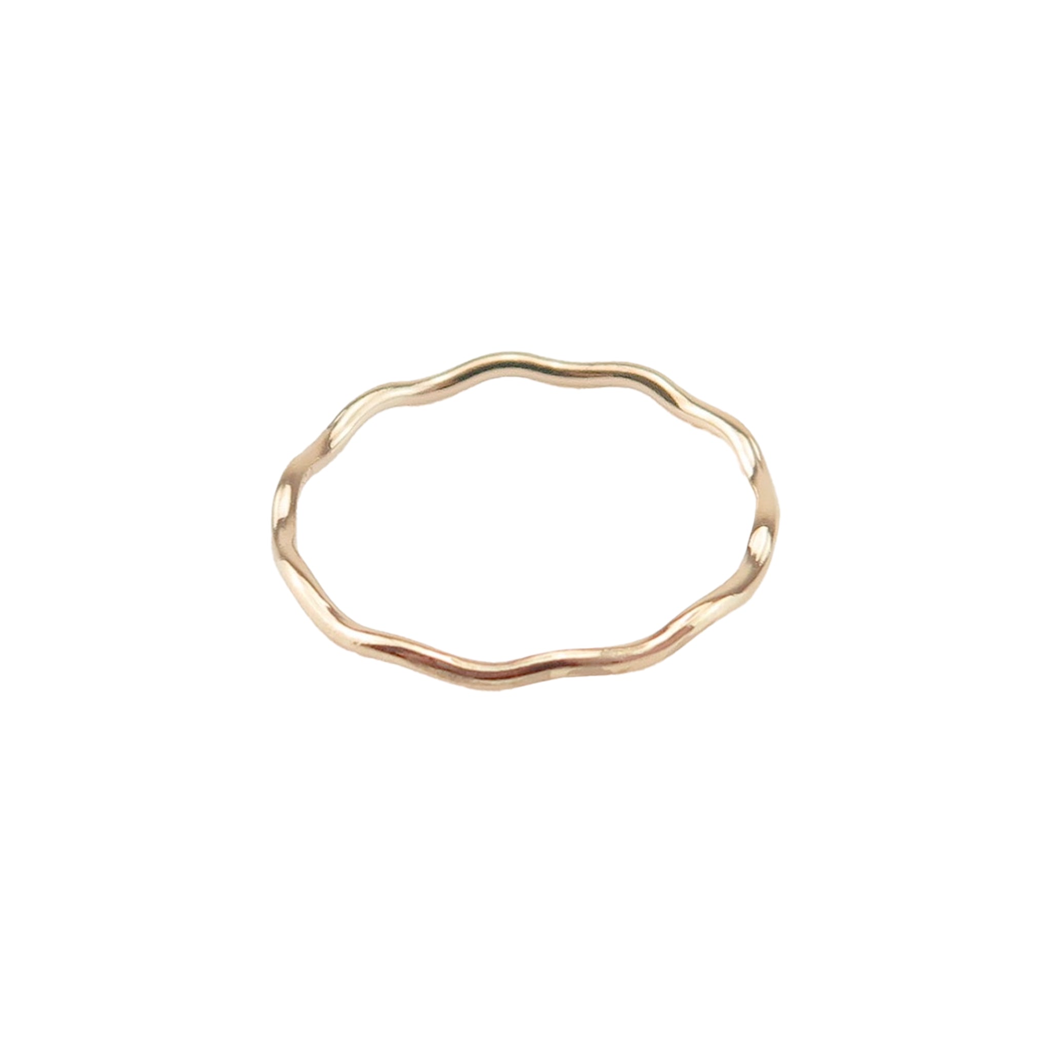 A gold stacking ring with a wave design on a white background.