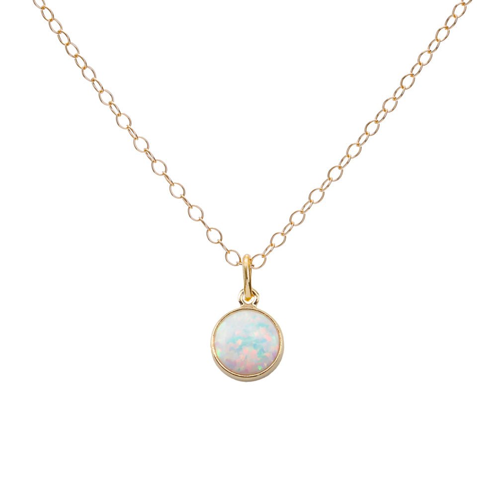 Gold necklace with a round opal pendant on a white background