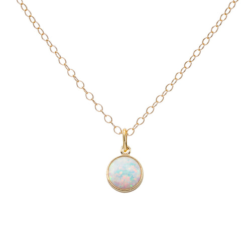 Gold necklace with a round opal pendant on a white background